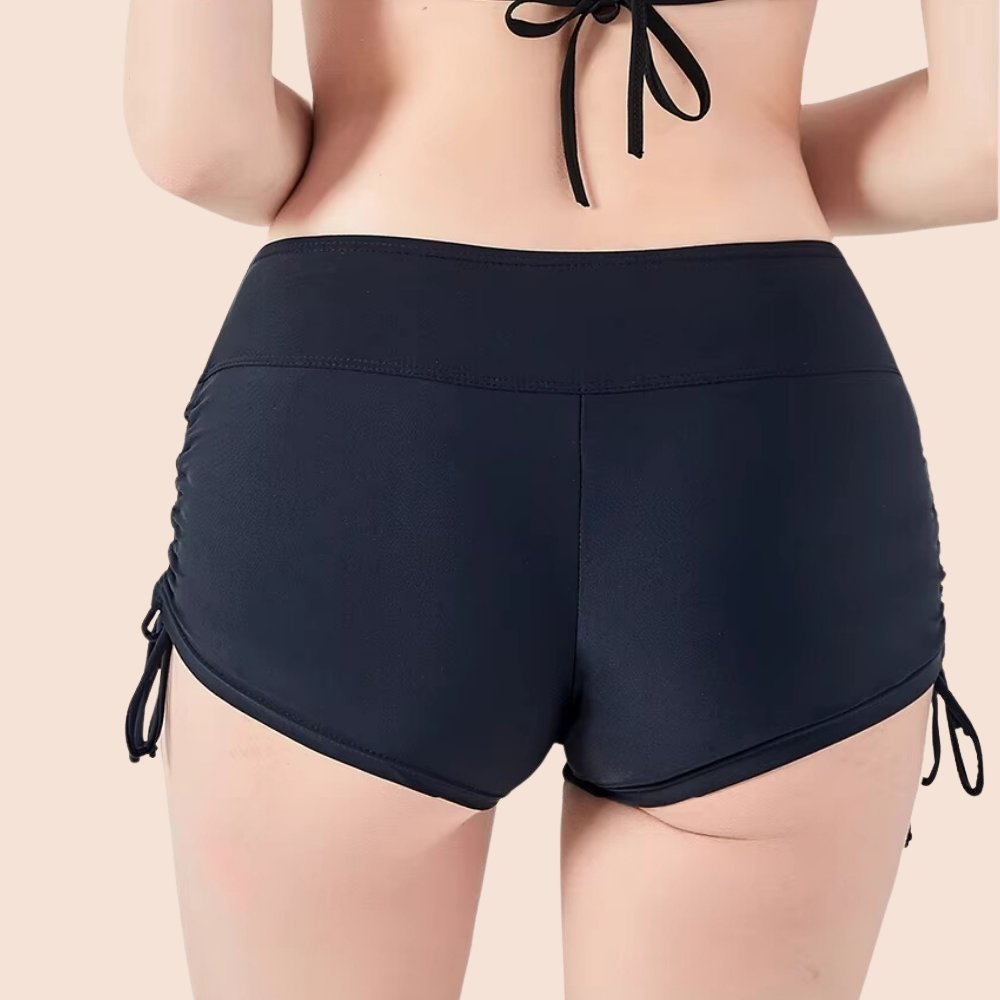 Rückansicht der schwarzen Perioden Bademode – elastische, saugfähige Shorts mit hoher Taille und verstellbaren Schnüren.